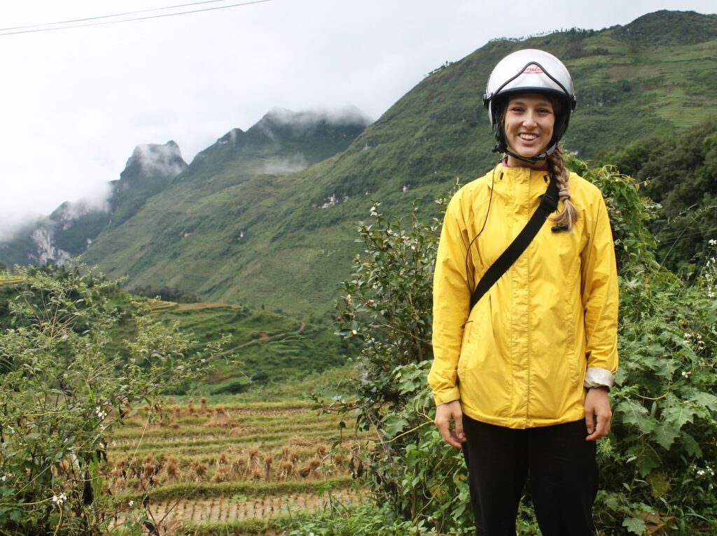 IMG_4950.jpg Teacher in yellow jacket standing in rural mountain landscape in Vietnam