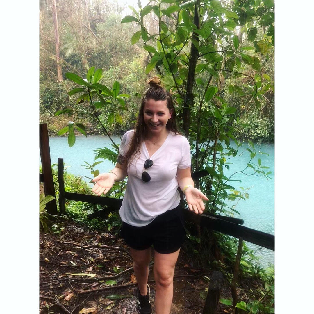 Pic2 Woman standing on a forest path in Costa Rica beside a blue river.